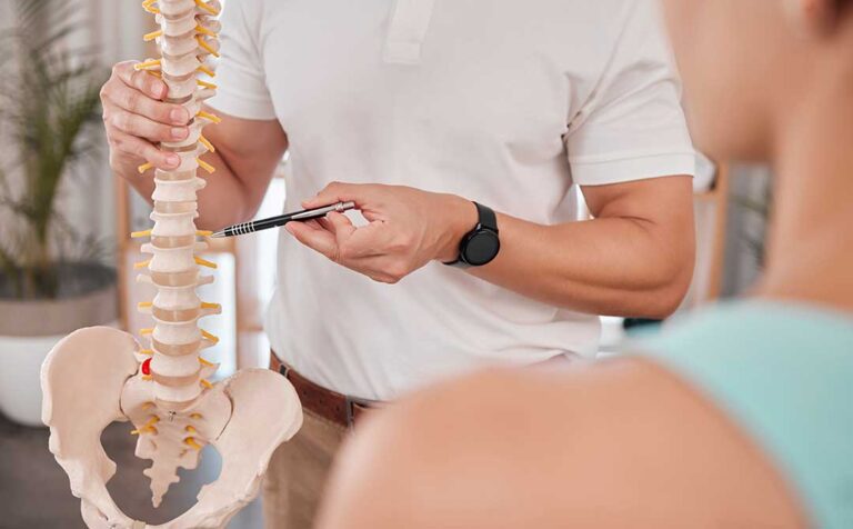 A chiropractor performing a spinal adjustment on a patient lying face down on a treatment table.